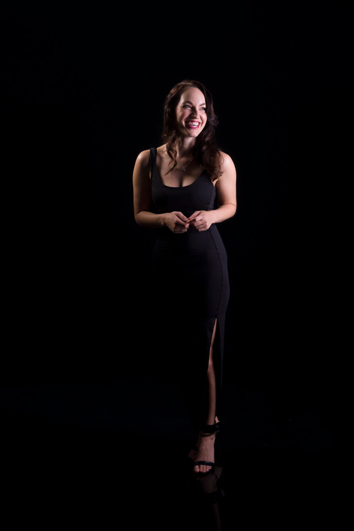 A couple standing close together in dark studio light